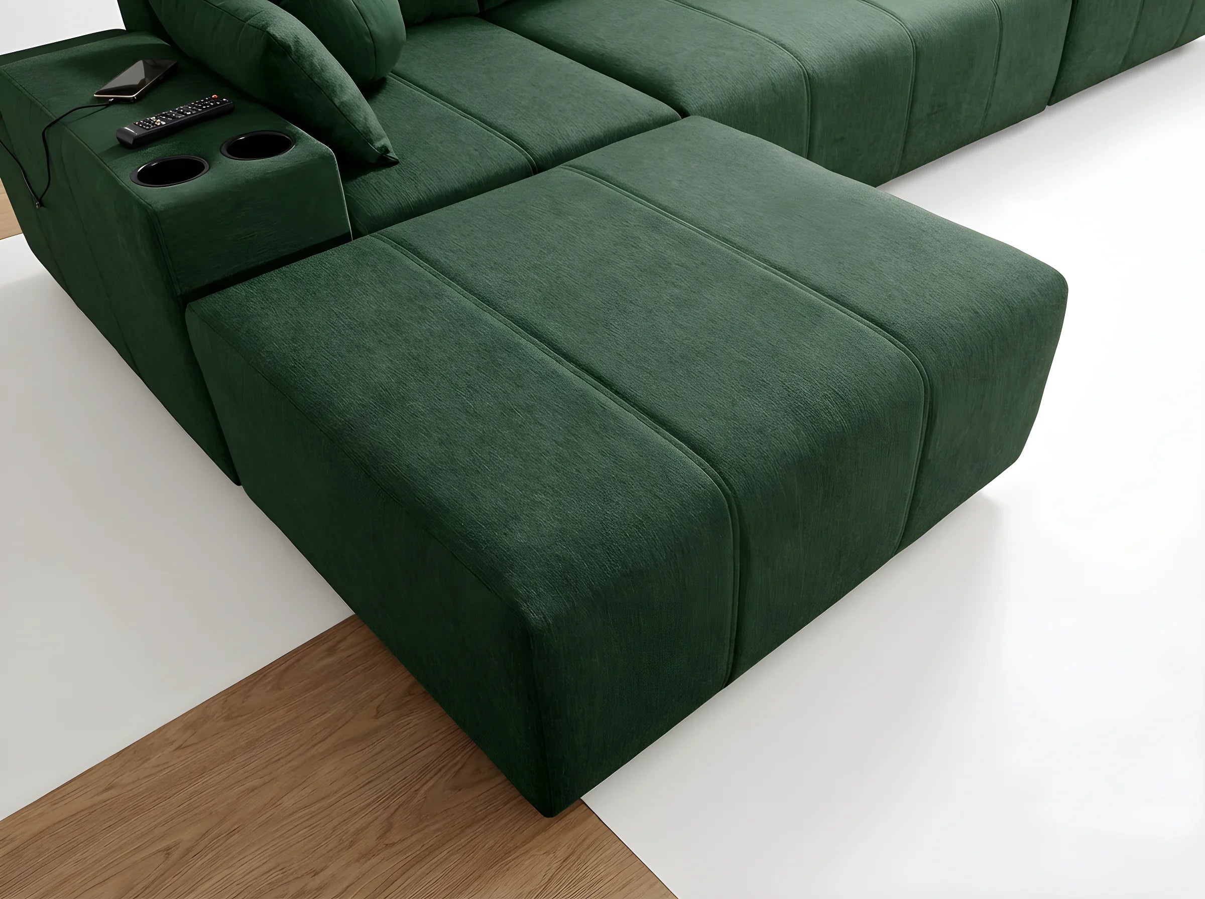 Canapé d'angle vert foncé en tissu, forme rectangulaire, avec accoudoir et porte-gobelets, dans un salon moderne