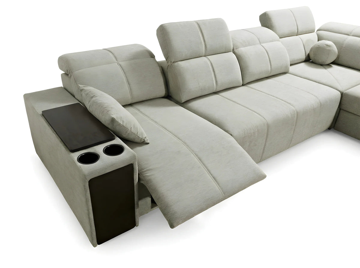 Canapé d'angle gris clair en tissu capitonné avec accoudoir, porte-gobelets et coussins, sur fond blanc